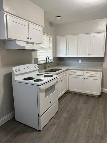 a white kitchen with a sink and cabinets