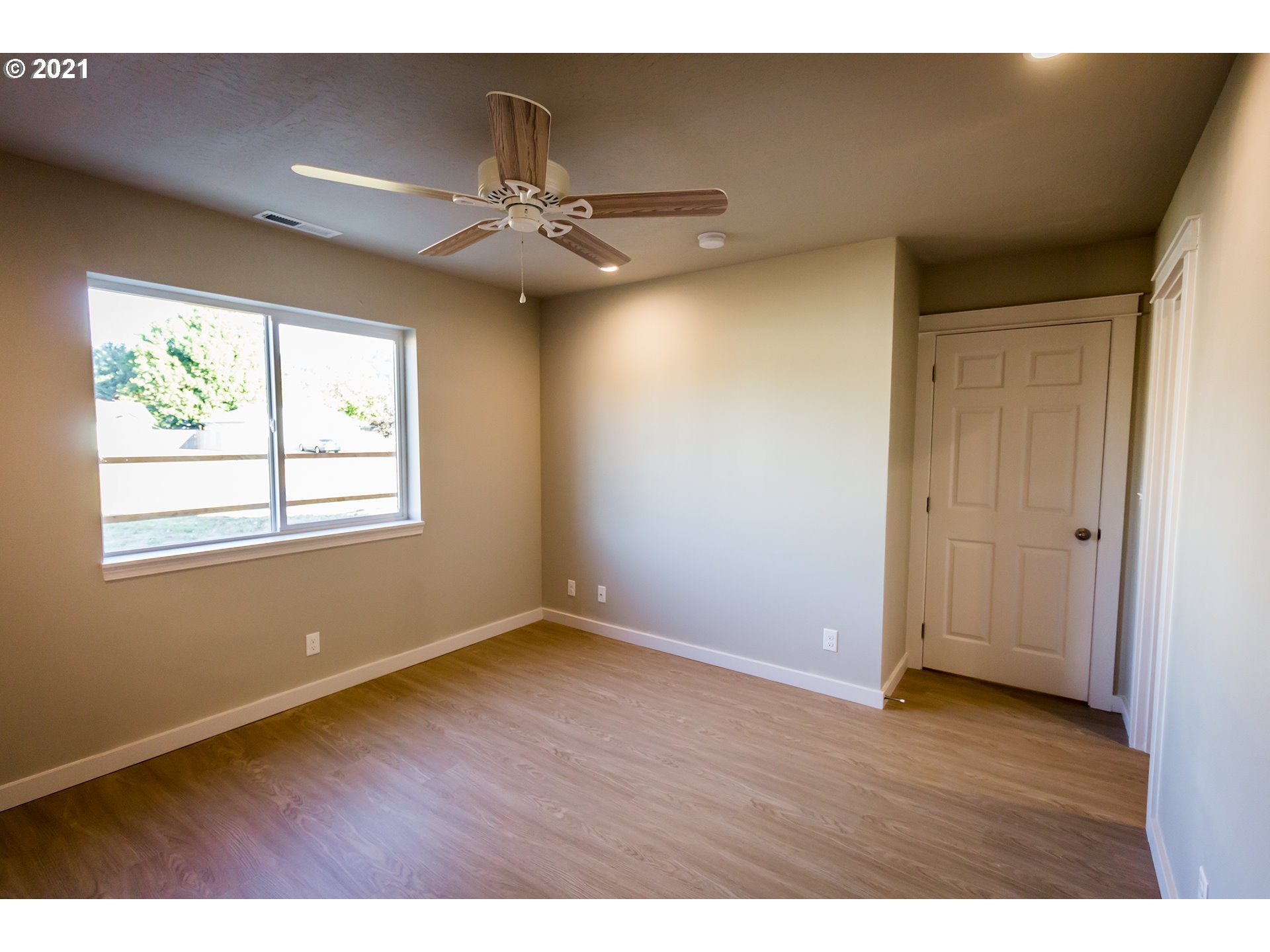156 65th Place Springfield, OR 97478 - Photo 8 of 24 a view of an empty room with wooden floor and a window