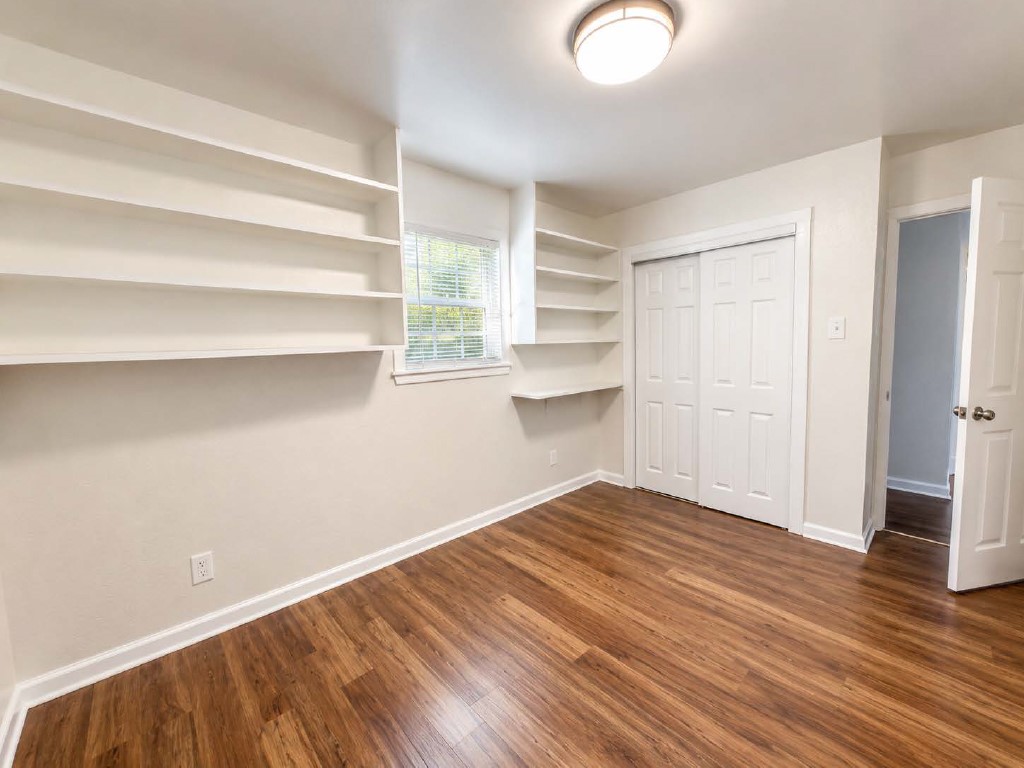 610 Gunter Street Austin, TX 78702 - Photo 9 of 16 Built-in shelving and wood flooring enhance this versatile space, ready for your personal touch.
