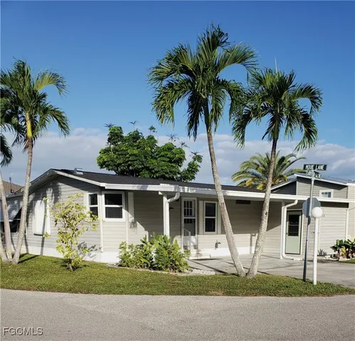 a front view of a house with a yard and potted plants