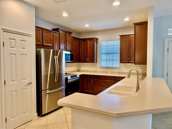 a kitchen with stainless steel appliances granite countertop a refrigerator and a sink