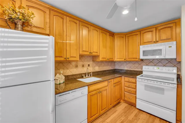 a kitchen with granite countertop cabinets stainless steel appliances and a large window