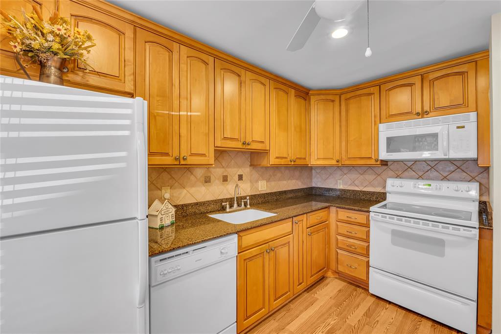 a kitchen with granite countertop cabinets stainless steel appliances and a large window
