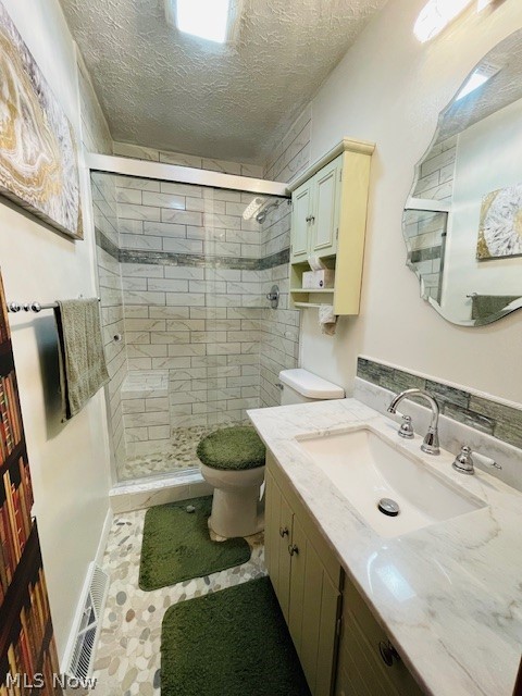9692 Hess Mill Road Northeast Bolivar, OH 44612 - Photo 6 of 33 Bathroom featuring a shower with door, a textured ceiling, tile patterned floors, toilet, and vanity