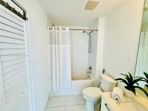 a bathroom with a toilet and a shower curtain