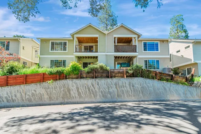 a view of a street with potted plants and large trees