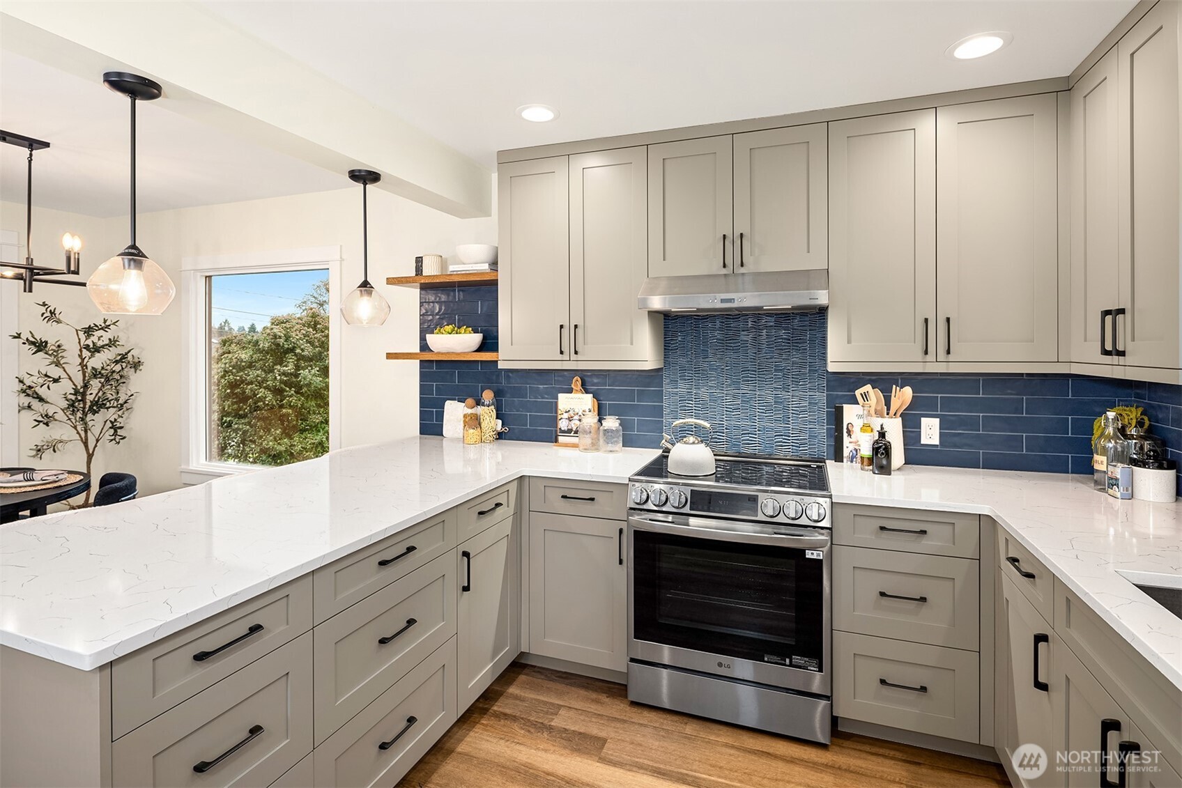 721 North 97th Street Seattle, WA 98103 - Photo 11 of 35 a kitchen with stainless steel appliances granite countertop a stove and white cabinets
