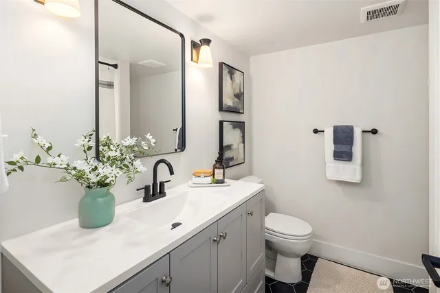 a bathroom with a sink a toilet and mirror