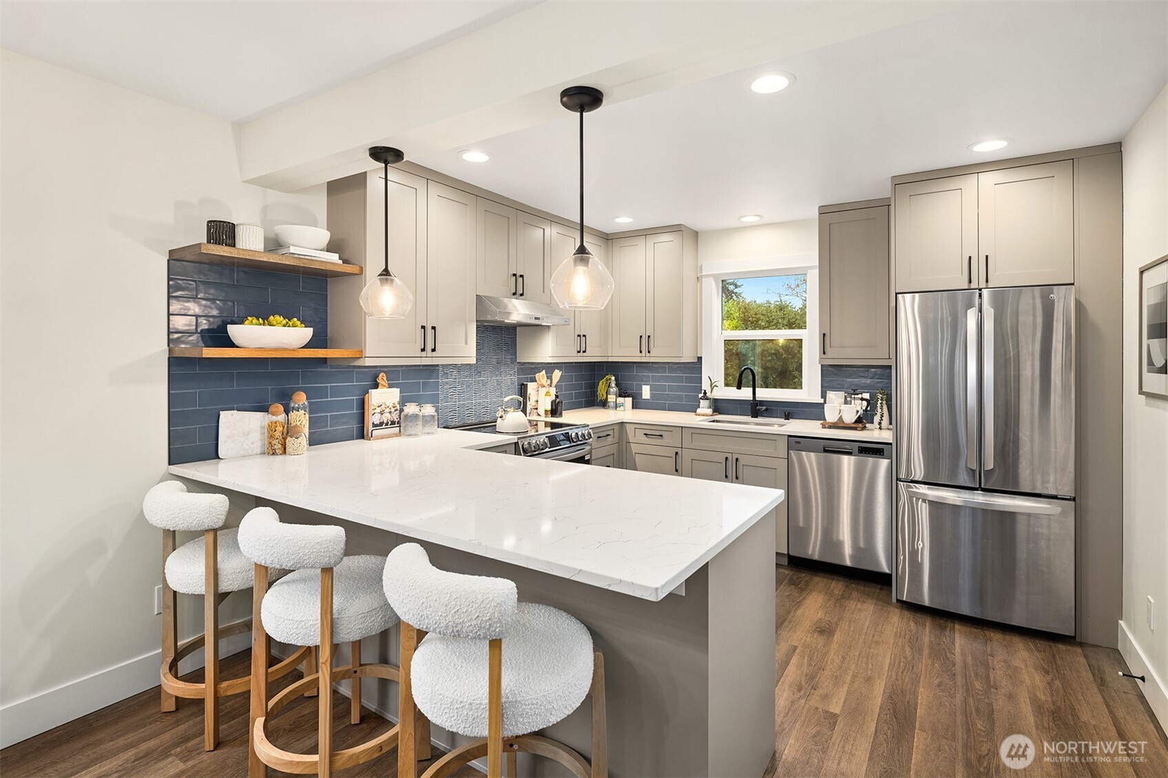 721 North 97th Street Seattle, WA 98103 - Photo 9 of 35 a kitchen with stainless steel appliances kitchen island granite countertop a refrigerator a stove and white cabinets with wooden floor
