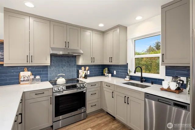 a kitchen with a white stove top oven sink and cabinets