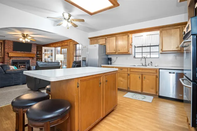 a kitchen with stainless steel appliances a sink a stove a dining table and chairs