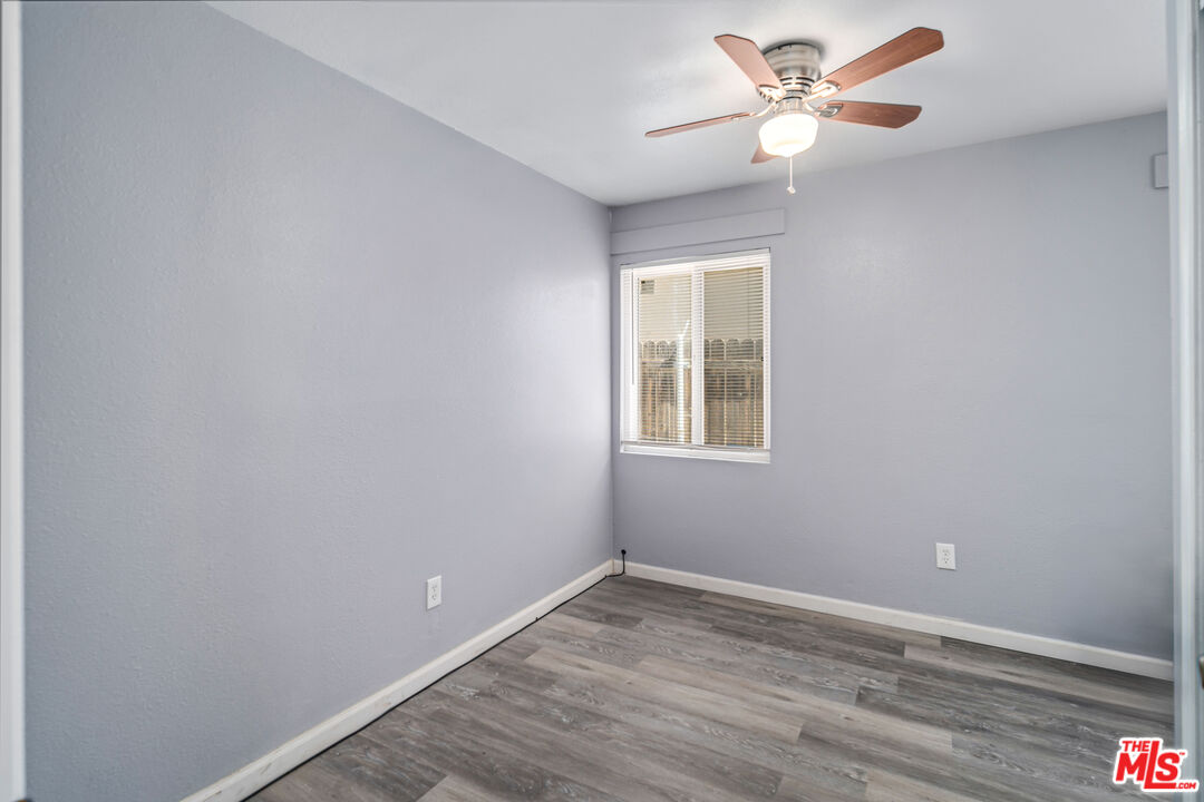 15872 Rexroth Drive Mojave, CA 93501 - Photo 14 of 20 a view of an empty room with a window and wooden floor