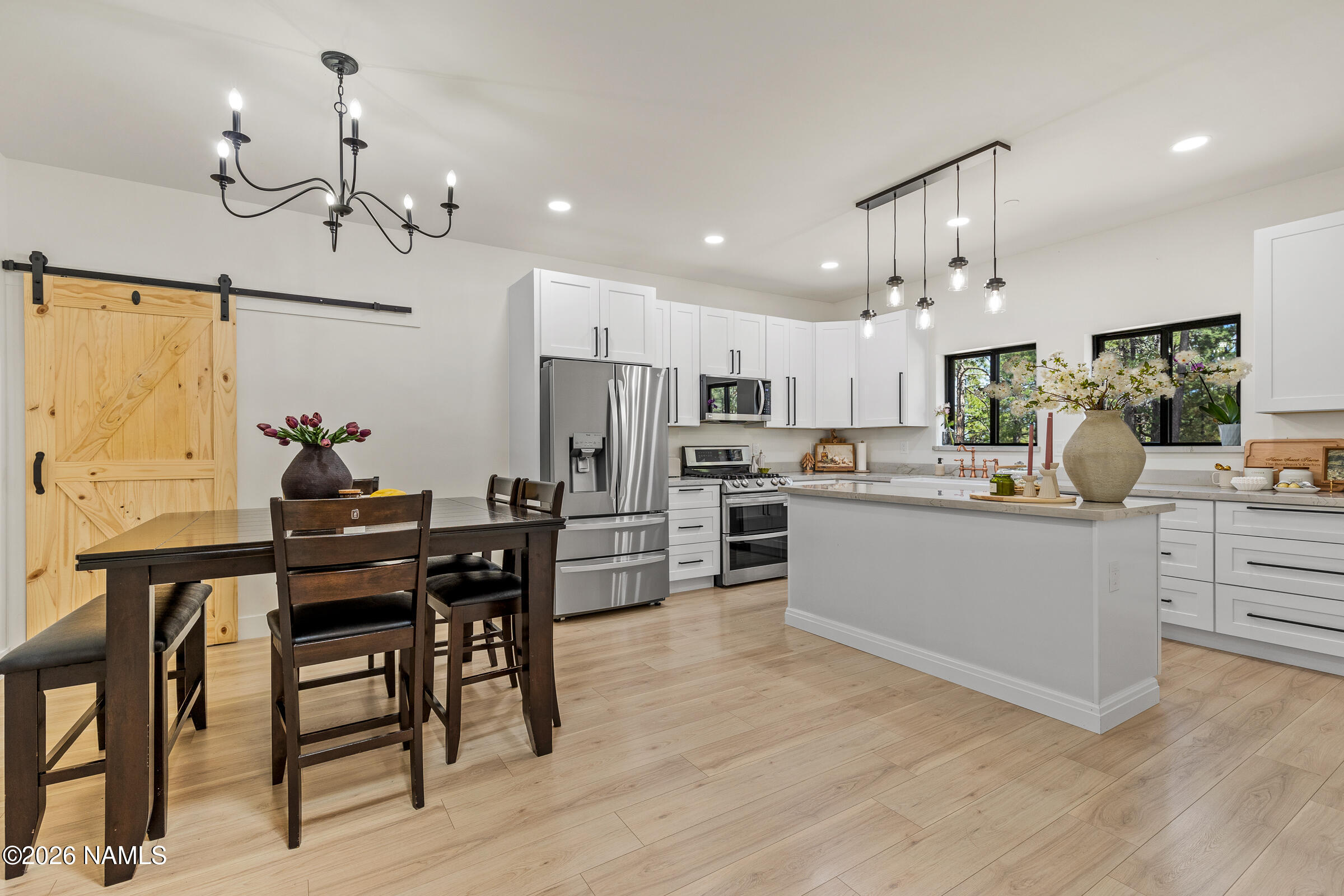 1113 Redwall Way Williams, AZ 86046 - Photo 13 of 53 a kitchen with stainless steel appliances kitchen island granite countertop a table chairs and a refrigerator