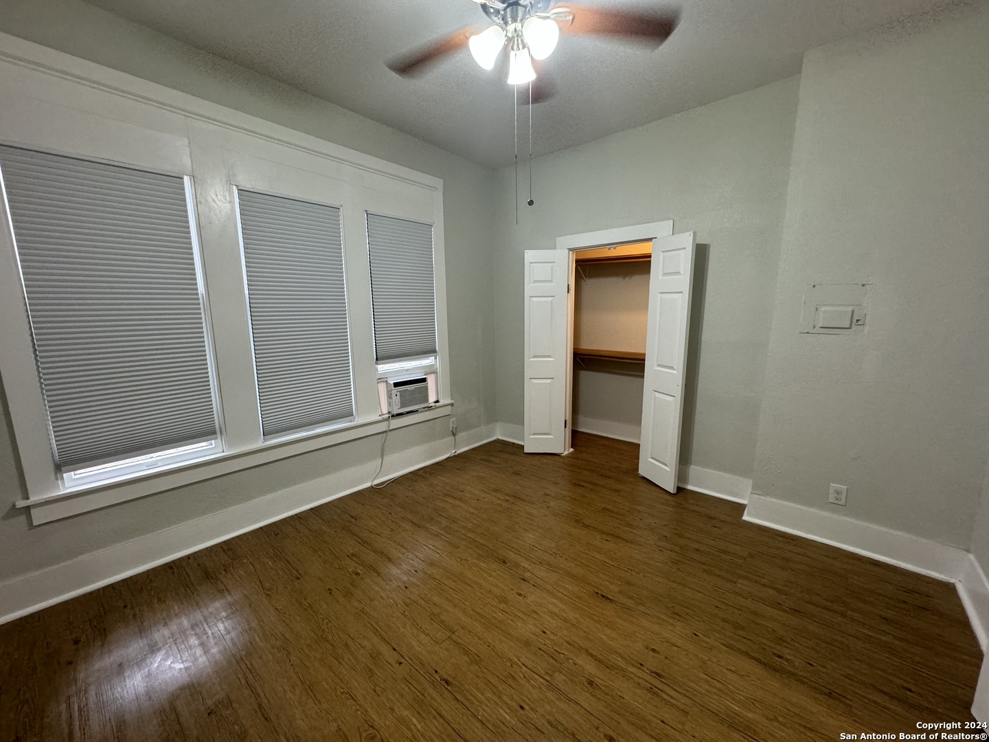 407 East Locust Street, Unit 2 San Antonio, TX 78212 - Photo 5 of 7 a view of an empty room with wooden floor and a window