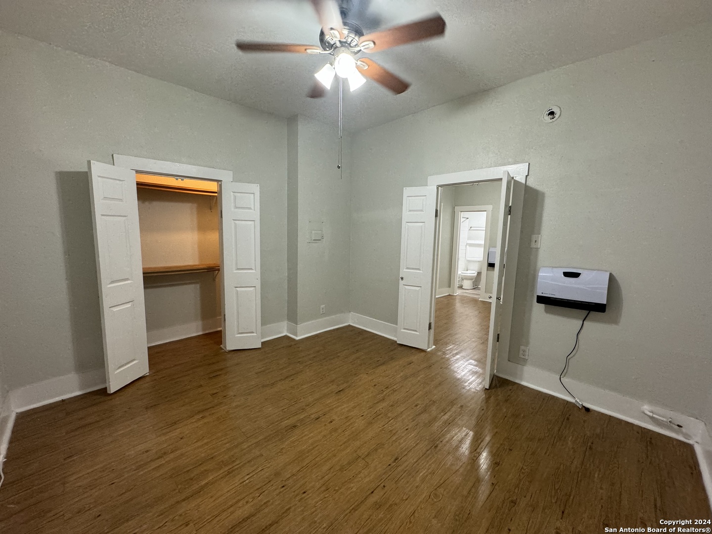 407 East Locust Street, Unit 2 San Antonio, TX 78212 - Photo 6 of 7 a view of an empty room with wooden floor and a ceiling fan