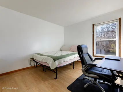 a bedroom with a bed a desk and chair