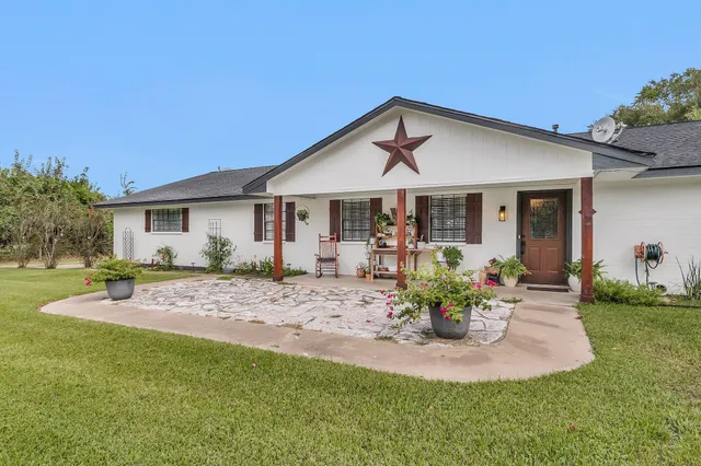 a view of a house with table and chairs in patio