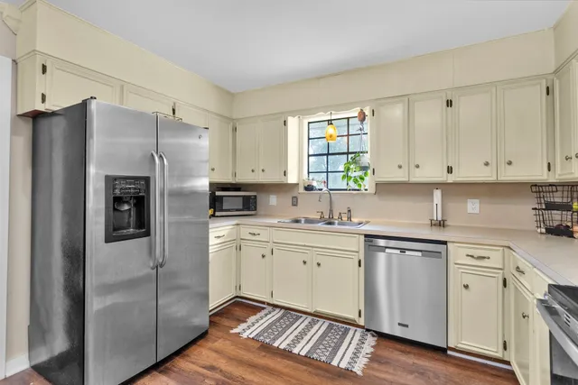 a kitchen with a refrigerator sink and cabinets
