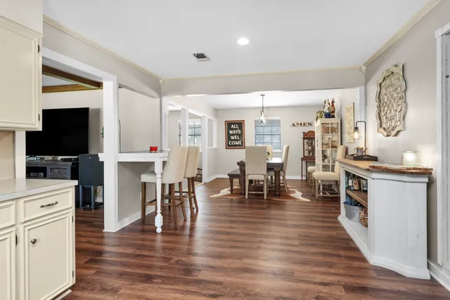a living room with stainless steel appliances furniture and a flat screen tv