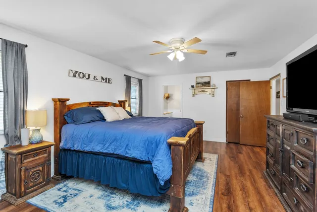 a bedroom with a bed and wooden floor