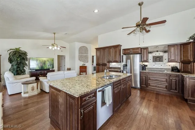 a kitchen with stainless steel appliances granite countertop a stove refrigerator and cabinets