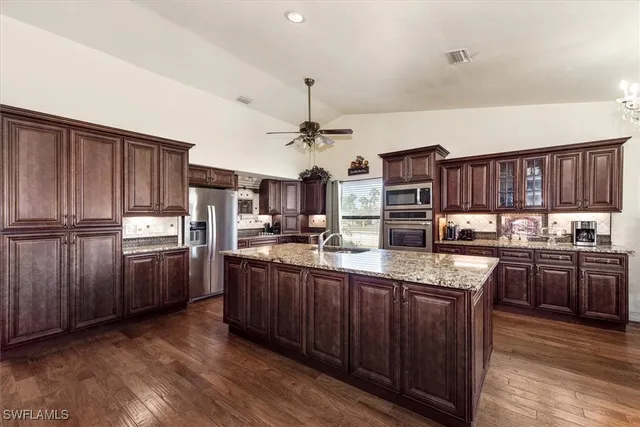 a kitchen with stainless steel appliances granite countertop a stove refrigerator and cabinets