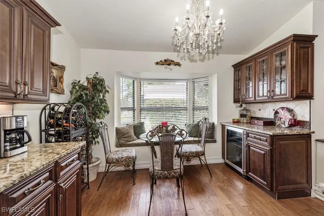 a view of a dining room with furniture a chandelier and wooden floor