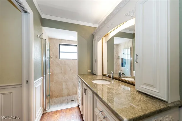 a bathroom with a granite countertop sink a mirror and a shower
