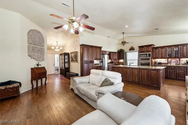 a living room with furniture kitchen view and a chandelier
