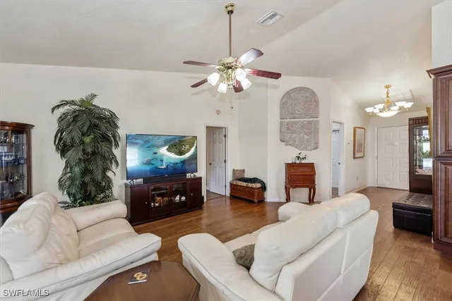 a living room with furniture a fireplace and a chandelier