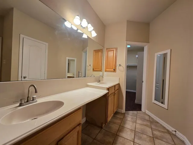 a bathroom with a sink double vanity granite and a mirror