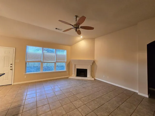 an empty room with windows and fan
