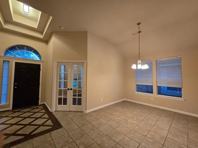 a view of an empty room with window and cabinet