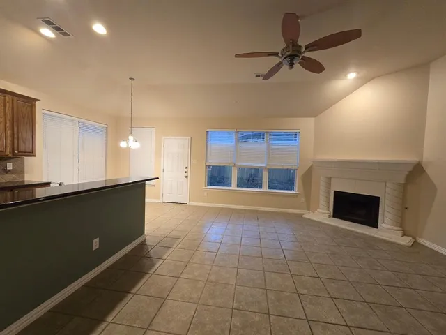 a view of an empty room with a fireplace and a window