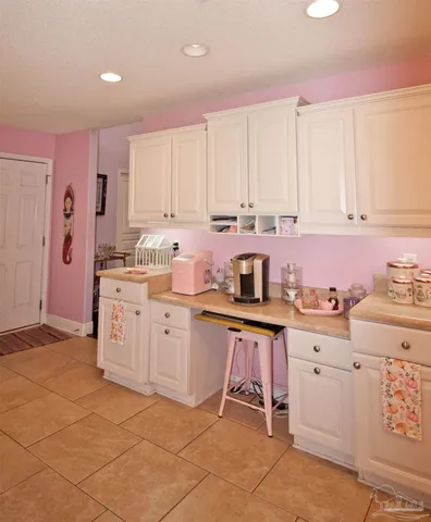 a kitchen with kitchen island granite countertop a stove a sink a dining table and chairs