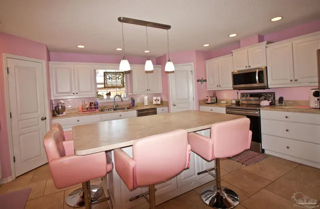 a kitchen with kitchen island granite countertop a sink counter top space appliances and cabinets