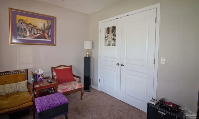 a bedroom with a bed dresser and a large window