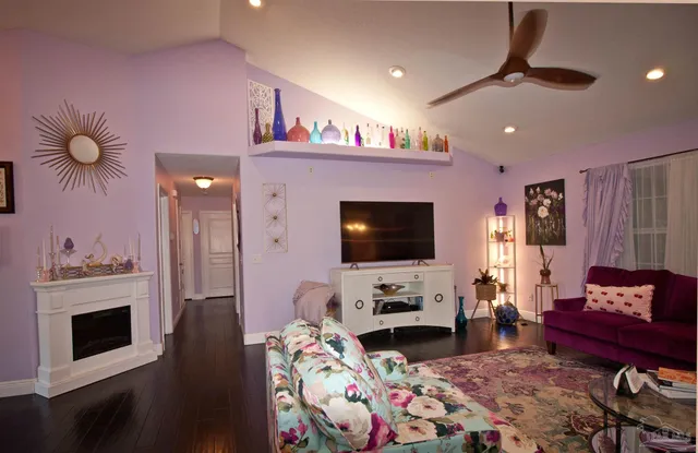 a living room with furniture a fireplace and a flat screen tv