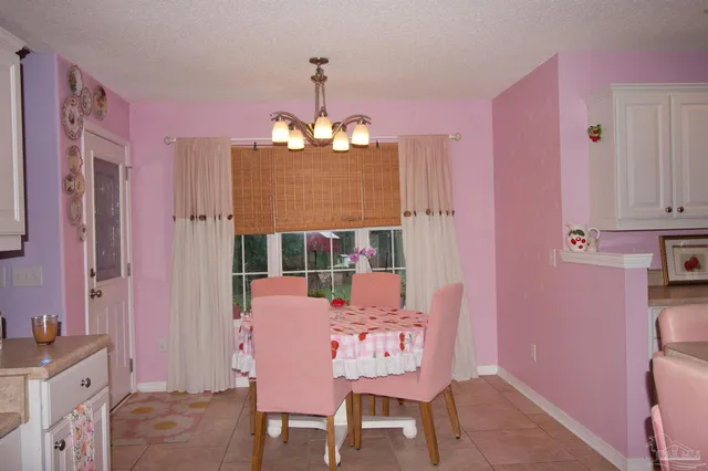 a bedroom with a bed a chandelier and a window