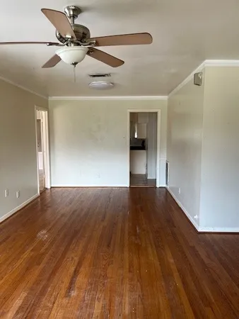 a view of empty room with wooden floor