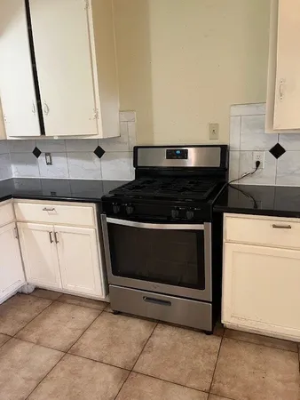 a stove top oven sitting inside of a kitchen
