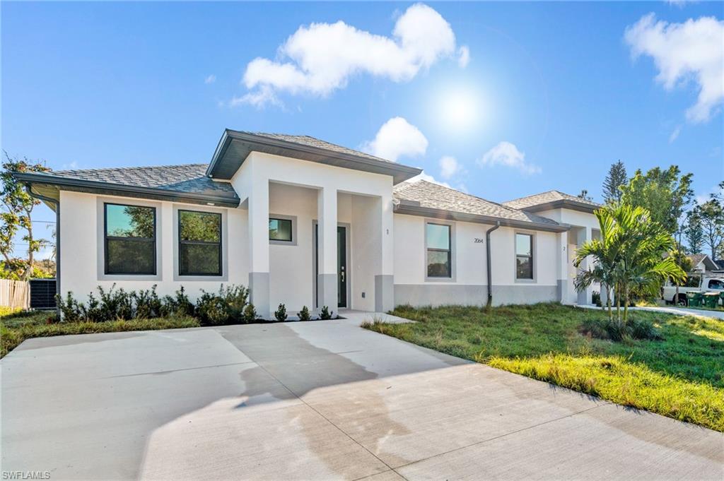 Prairie-style home featuring stucco siding and a front lawn