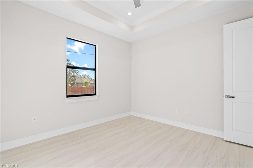2064 55th Terrace Southwest Naples, FL 34116 - Photo 16 of 30 Unfurnished room with a raised ceiling, recessed lighting, and light floors