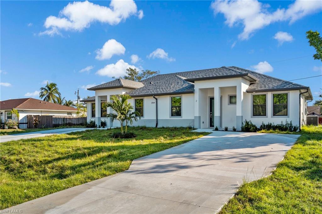 2064 55th Terrace Southwest Naples, FL 34116 - Photo 2 of 30 Prairie-style home with stucco siding and driveway