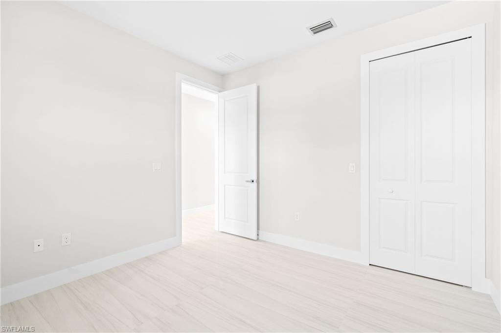 2064 55th Terrace Southwest Naples, FL 34116 - Photo 22 of 30 Unfurnished bedroom with a closet and light wood-type flooring