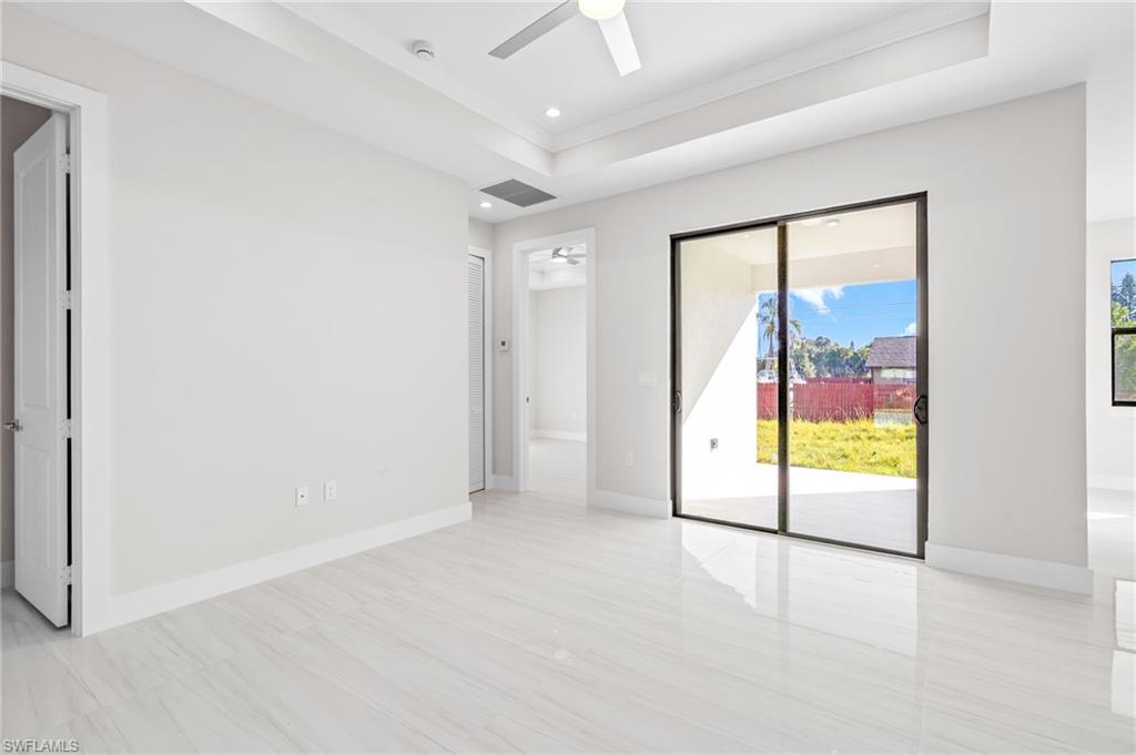 2064 55th Terrace Southwest Naples, FL 34116 - Photo 24 of 30 Spare room featuring ceiling fan, a tray ceiling, and recessed lighting