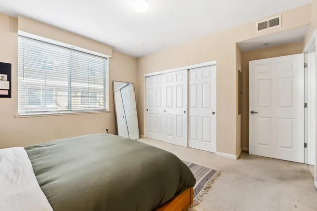 a bedroom with a bed closet and a window