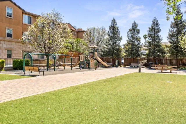 a view of a swimming pool with a bench and some trees