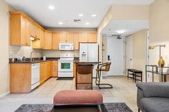 a kitchen with a table chairs refrigerator and cabinets