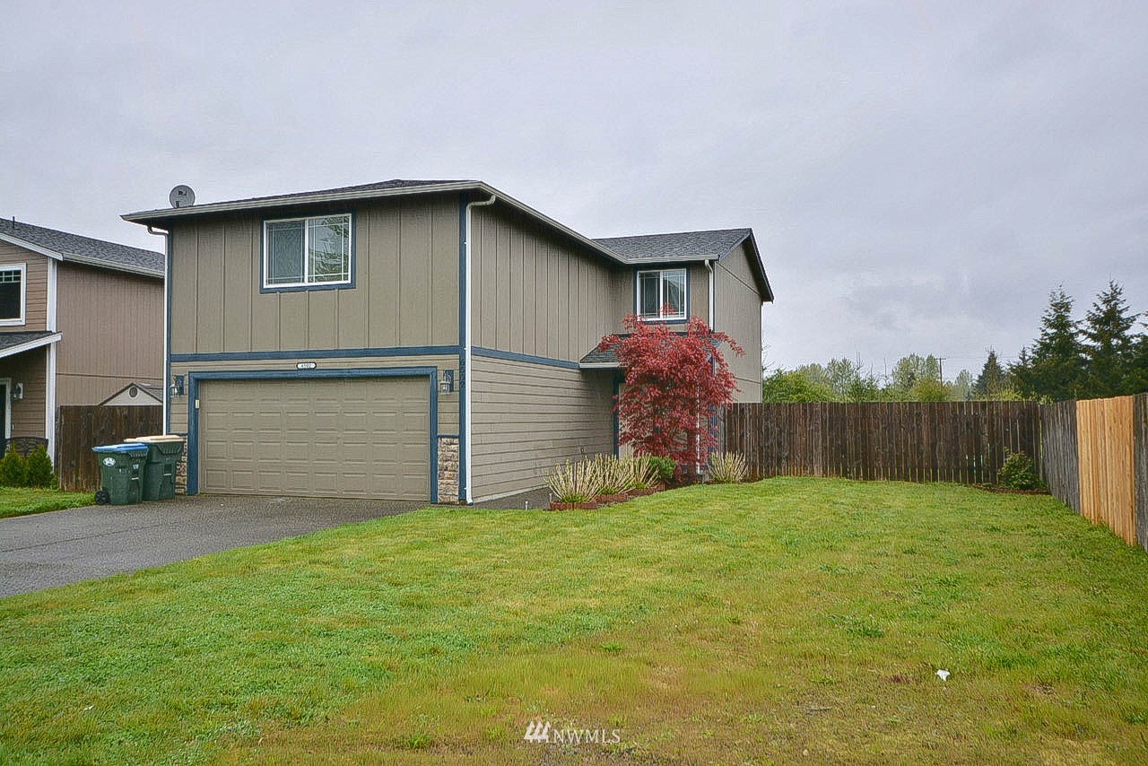 a view of a house with a yard and garage